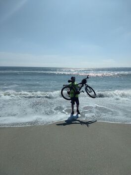 Standing in Atlantic Ocean after completing coast to coast bicycle ride